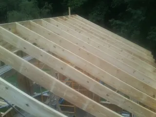 New roof rafters set over an addition before sheathing in Fayette